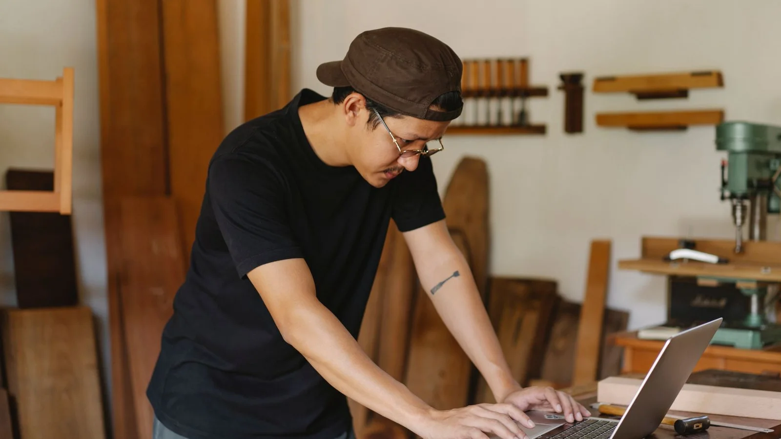 Woodworker using a laptop in his workshop
